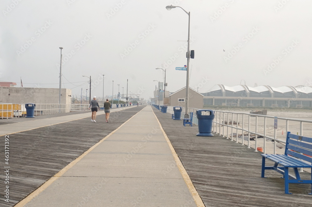 Two Female Pedestrians Strolling on Boardwalk Early Morning