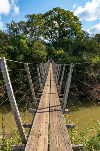 Fototapeta Naklejka Na Ścianę i Meble -  Wood and iron bridge over Cadeia river with forest around
