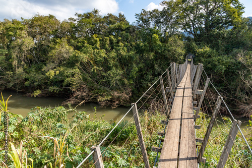 Fototapeta Naklejka Na Ścianę i Meble -  Wood and iron bridge over Cadeia river with forest around