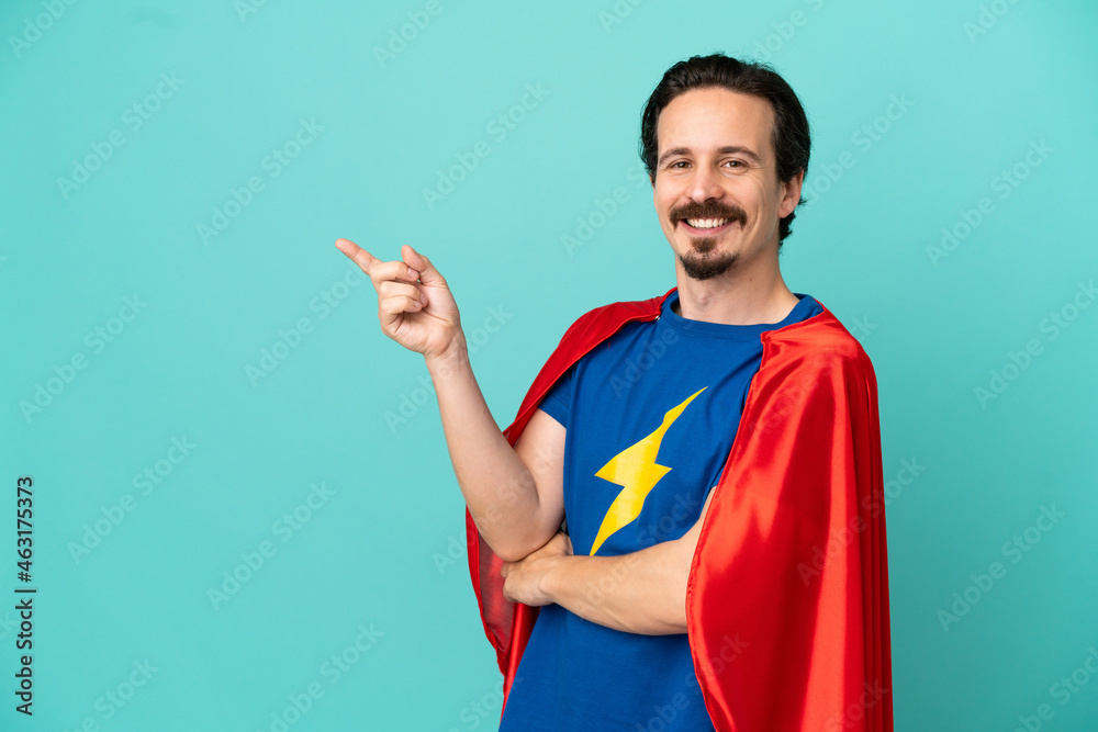 Super Hero caucasian man isolated on blue background pointing finger to the side Super Hero caucasian man isolated on blue background pointing finger to the side
