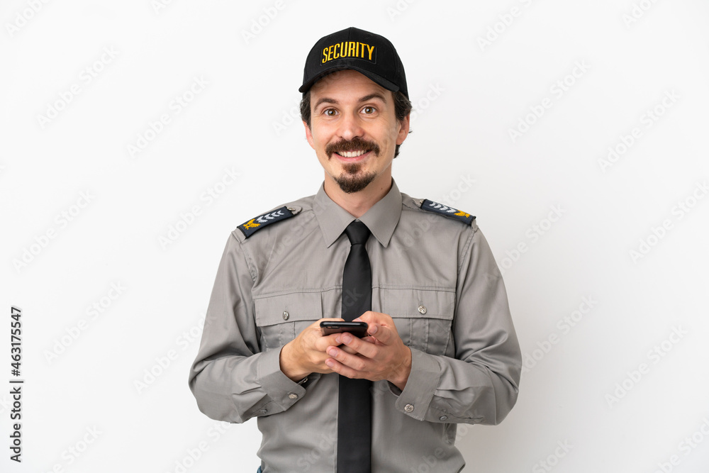 Young caucasian security man isolated on white background sending a message with the mobile Young caucasian security man isolated on white background sending a message with the mobile
