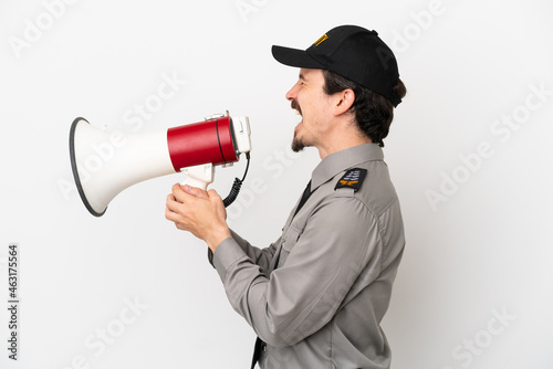Young caucasian security man isolated on white background shouting through a megaphone