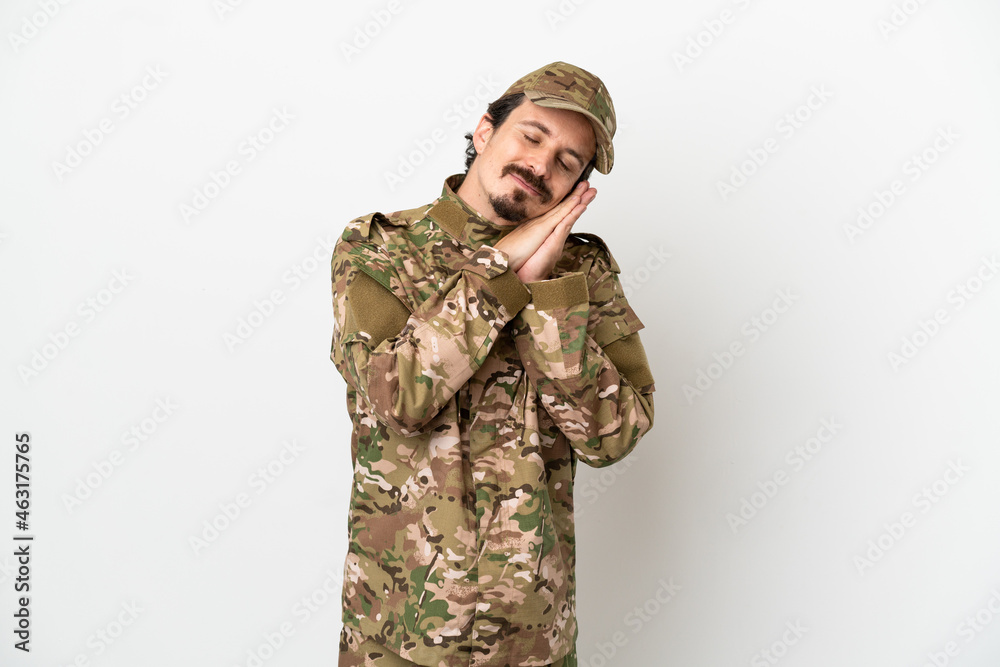 Soldier man isolated on white background making sleep gesture in dorable expression Soldier man isolated on white background making sleep gesture in dorable expression