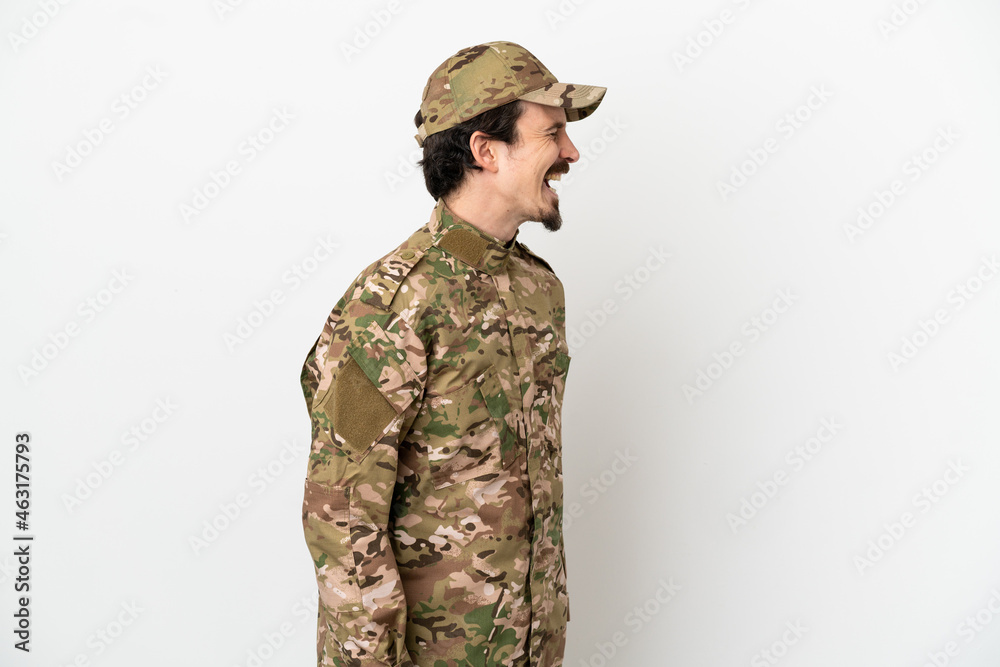 Soldier man isolated on white background laughing in lateral position Soldier man isolated on white background laughing in lateral position