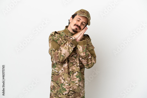 Soldier man isolated on white background making sleep gesture in dorable expression
