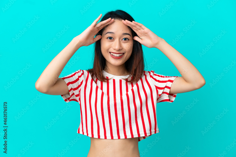 Young Vietnamese woman isolated on blue background with surprise expression