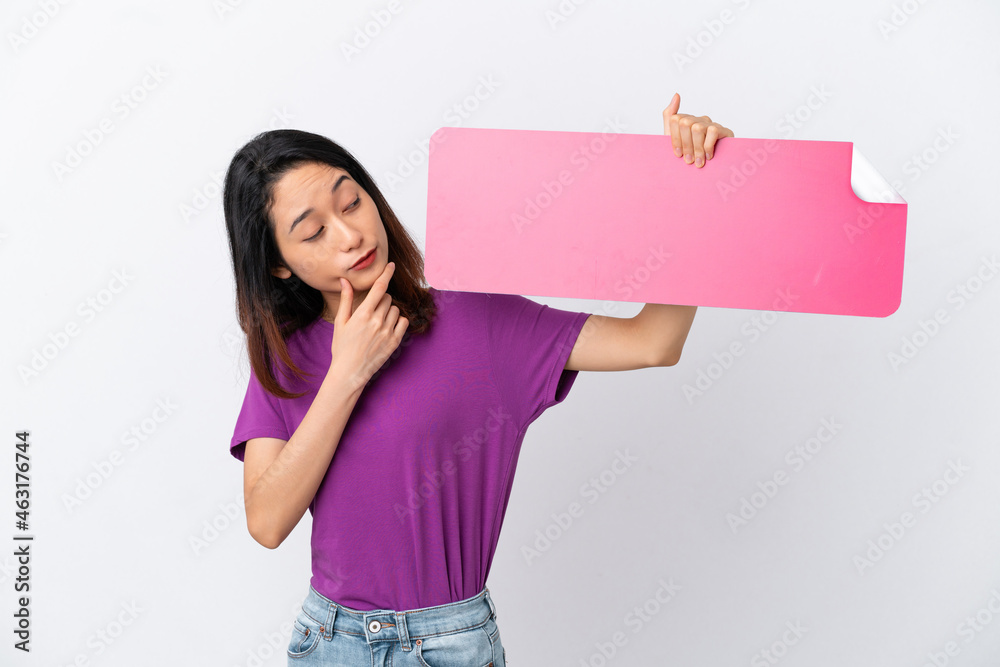 Young Vietnamese woman isolated on white background holding an empty placard and thinking