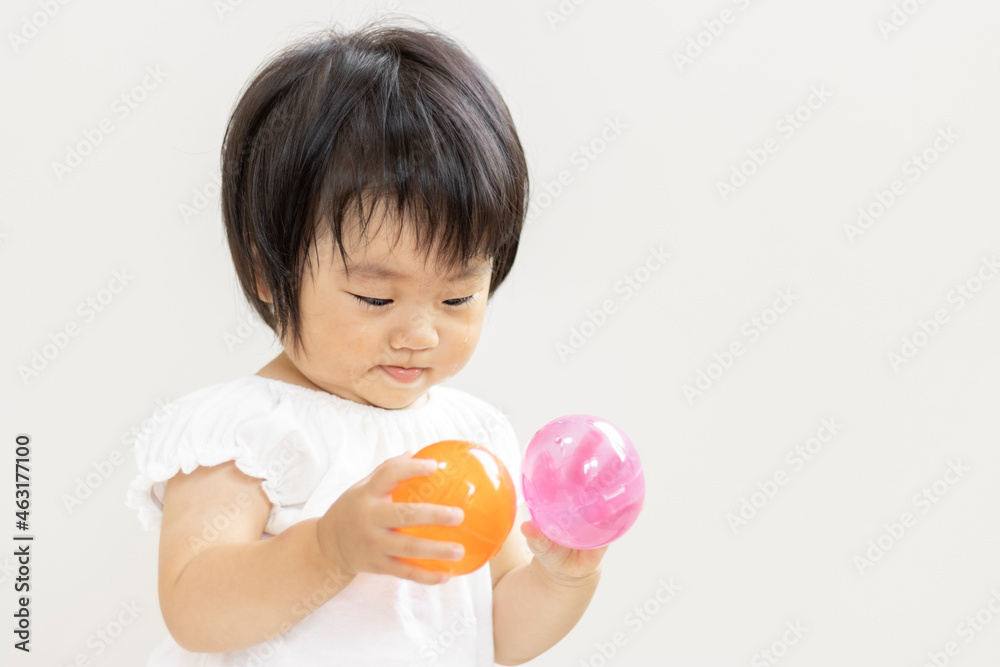 ガチャガチャのカプセルを持つ赤ちゃん(1歳2か月、日本人、女の子) ガチャガチャのカプセルを持つ赤ちゃん(1歳2か月、日本人、女の子)