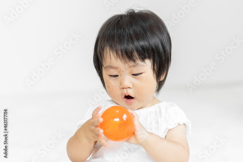 Obraz na płótnie ガチャガチャのカプセルを持つ赤ちゃん(1歳2か月、日本人、女の子) w salonie