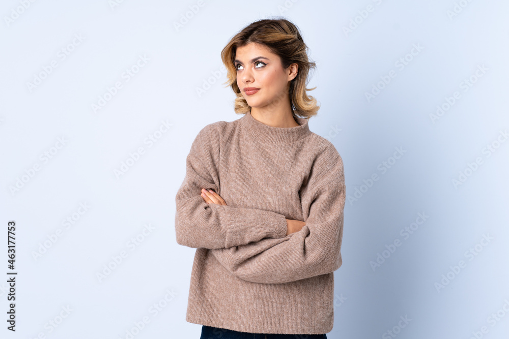 Young Russian woman isolated on blue background making doubts gesture while lifting the shoulders Young Russian woman isolated on blue background making doubts gesture while lifting the shoulders