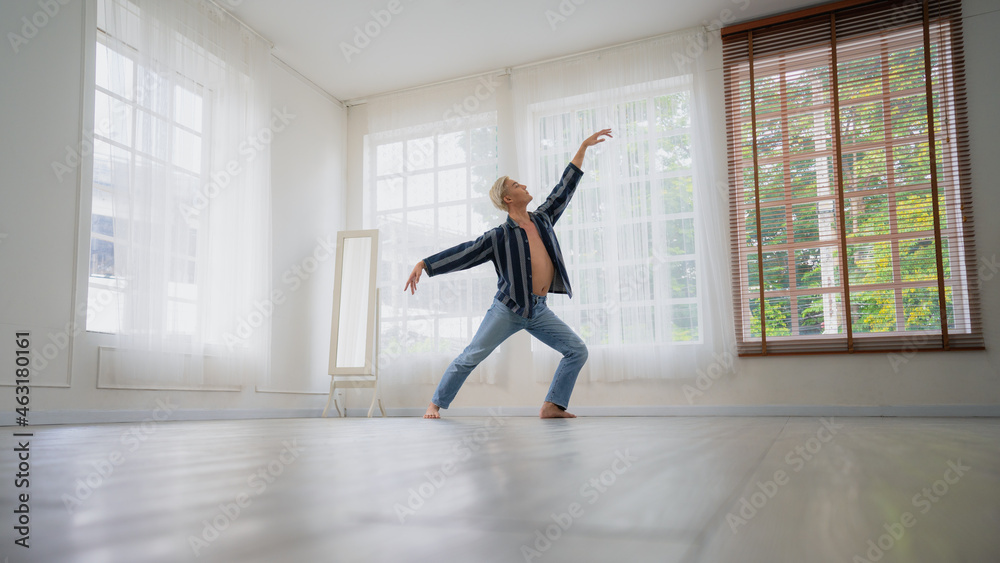 Fototapeta premium Asian Male ballet dancer of dancing in room with glass windows and white curtain. Exercise at home with new normal lifestyle.
