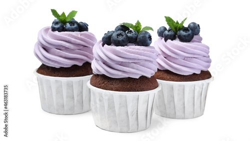 Sweet cupcakes with fresh blueberries on white background