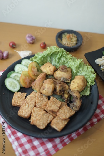 Fried chicken (ayam goreng) and tempeh (tempe) with bean sprouts (tauge) on a table 