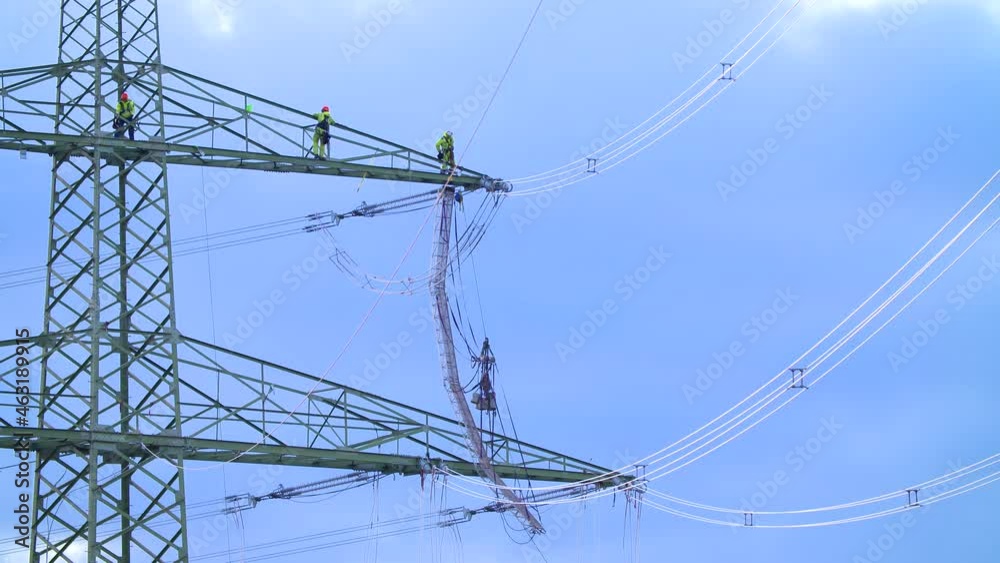 Linemen working at great heights on a side boom of a power pylon Linemen working at great heights on a side boom of a power pylon