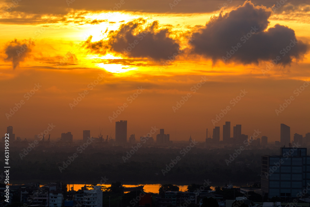 The blurred abstract background of the morning sun exposure to the tiny dust particles that surround the tall buildings in the capital, the long-term health issue of pollution.