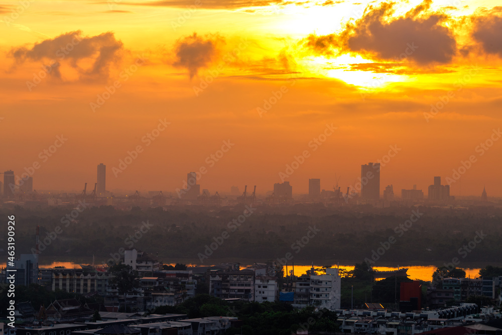 Fototapeta premium The blurred abstract background of the morning sun exposure to the tiny dust particles that surround the tall buildings in the capital, the long-term health issue of pollution.