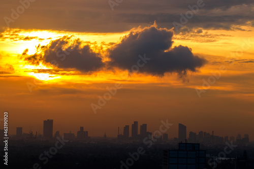 The blurred abstract background of the morning sun exposure to the tiny dust particles that surround the tall buildings in the capital, the long-term health issue of pollution.