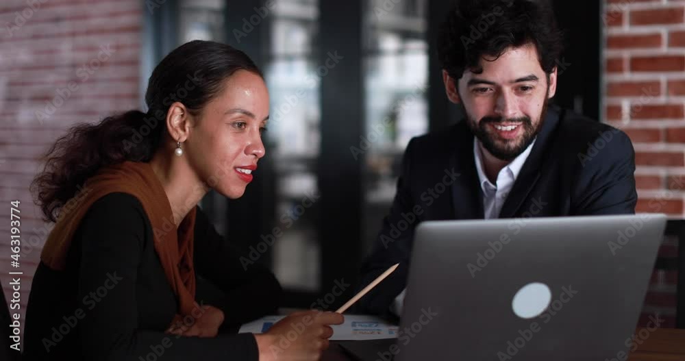 Diverse people, Latin American businesswoman and caucasian man, sit and working together in office. Diversity colleagues discuss idea with laptop computer with intimate and professional relations. Diverse people, Latin American businesswoman and caucasian man, sit and working together in office. Diversity colleagues discuss idea with laptop computer with intimate and professional relations.