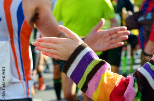 Marathon running race  supporting runners on road  child hand giving highfive  sport concept 