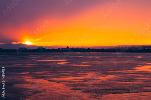 Sunset from the sea bay with a red-orange sky. Colorful sky at sunset Sea bay in the Canadian city of Quebec at a picturesque sunset.