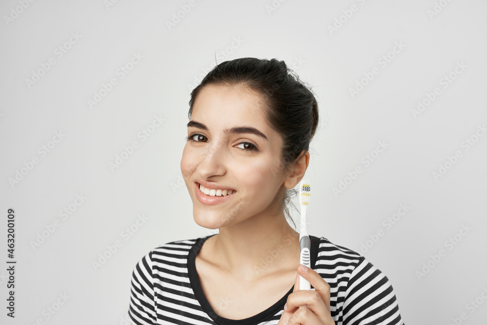 cheerful woman in a striped t-shirt toothbrush in hand isolated background cheerful woman in a striped t-shirt toothbrush in hand isolated background