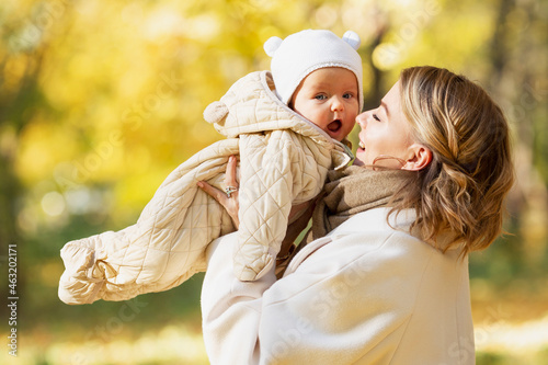 Laughing mom with her baby in an autumn park on a sunny day. Close-up. Love and tenderness. photo