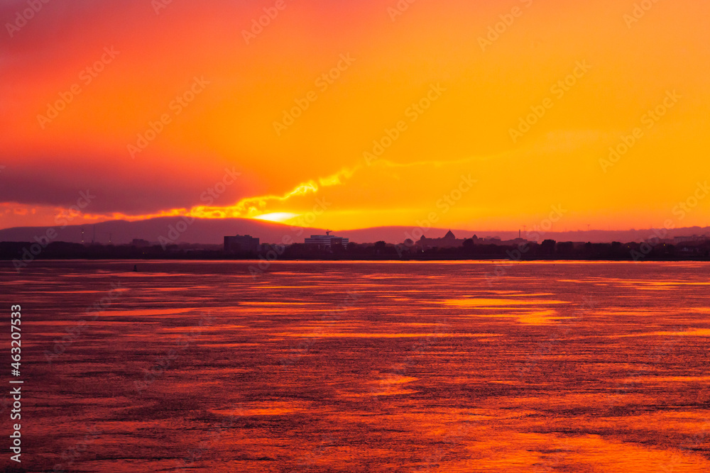Fototapeta premium Sunset from the sea bay with a red-orange sky. Colorful sky at sunset Sea bay in the Canadian city of Quebec at a picturesque sunset.