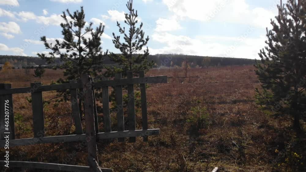 Gloomy video with an abandoned fence in the autumn forest. Video of a flight over the ground from an unmanned aerial vehicle. Autumn evening in nature. Gloomy video with an abandoned fence in the autumn forest. Video of a flight over the ground from an unmanned aerial vehicle. Autumn evening in nature.