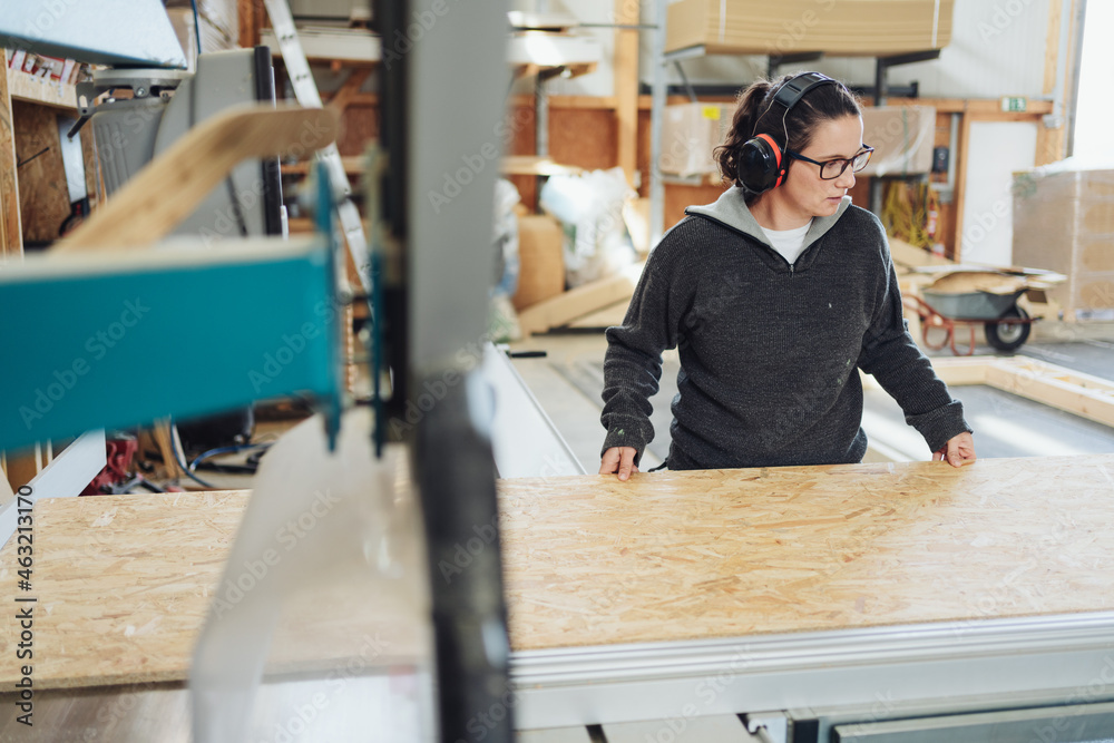 Female worker in a woodworking factory working with chipboard Female worker in a woodworking factory working with chipboard