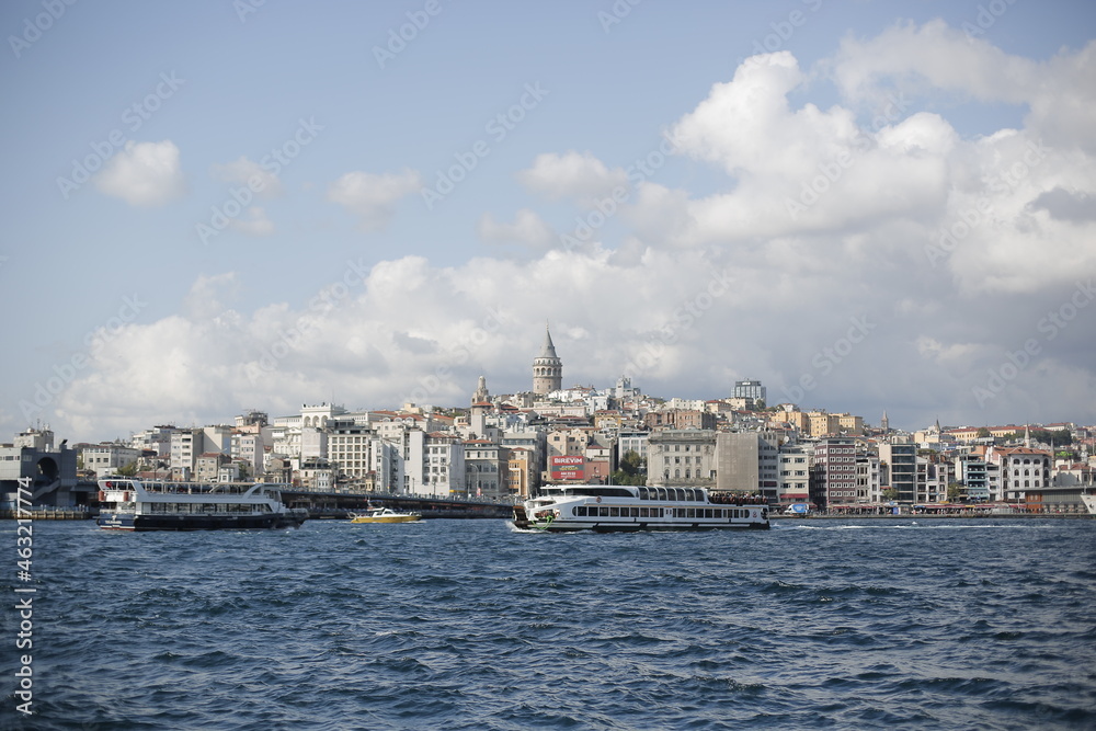 A tour on the coast of the Bosphorus in Istanbul - Turkey Boats and tourists on the Galata Bridge and Galata Tower and fishermen. Seagulls are flying, an old man and his wife are back watching the sun