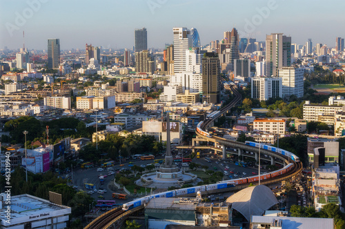 Aerial view of highway junctions with roundabout. Bridge roads shape circle in structure of architecture and transportation concept. Top view. Urban city, Bangkok at sunset, Thailand.