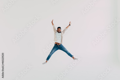 Handsome indian man jumping isolated on white background