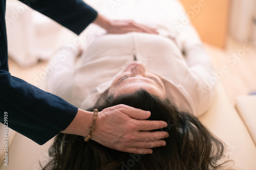 Therapist man doing Holistic therapy Reiki to a woman. Energy treatment with the heat of the palm hands. Japanese energy healing. Wellness, health, relax, well-being and alternative medicine concept. photo