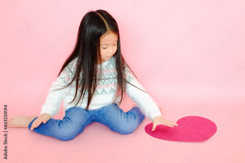 Portrait beautiful cute asian child girl on pink background with red heart sign, valentine day in love concept Portrait beautiful cute asian child girl on pink background with red heart sign, valentine day in love concept