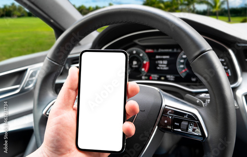 Driver hand using smartphone in car. Smartphone in a car use for Navigate or GPS. Mobile phone with isolated white screen. Blank empty screen. copy space. Empty space for text.