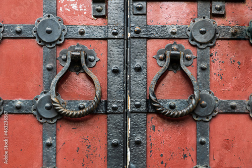 Fotografie Red ancient gates with the metal fittings and the round doorknobs