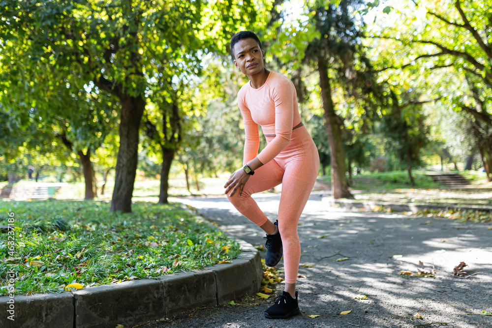 Female athlete has severe leg pain injury after morning jogging and fitness, African American woman in autumn park in the morning Female athlete has severe leg pain injury after morning jogging and fitness, African American woman in autumn park in the morning