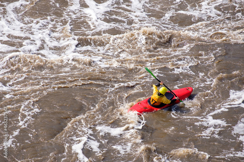 top view of a kayak with a man who is rowing down the river with all his might