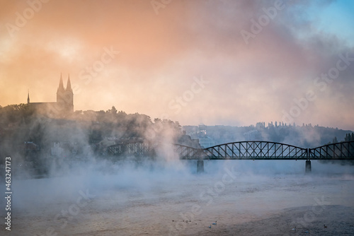 Amazing foggy view of Old Vysehrad Basilica of saint Peter and Pavel, Sunlight over historical building Vysehrad castle during autumn morning, Prague, Czech republic