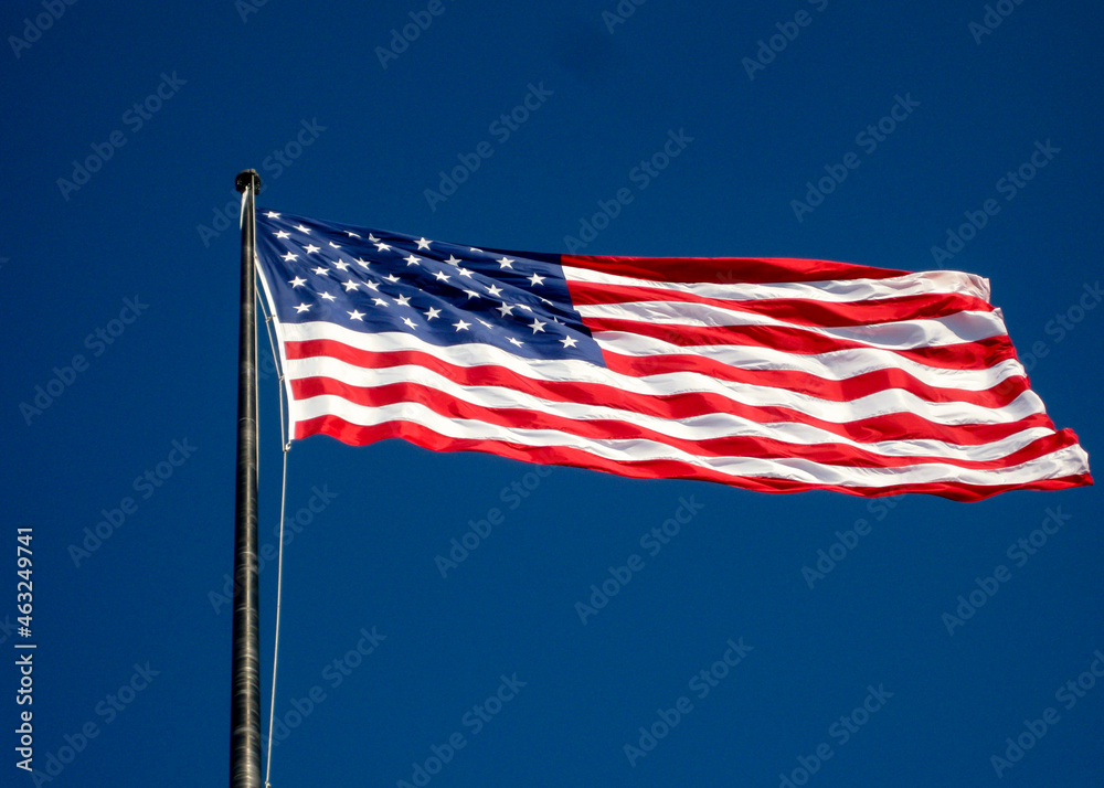 Obraz premium American flag, the Stars and Stripes, isolated against a deep blue sky