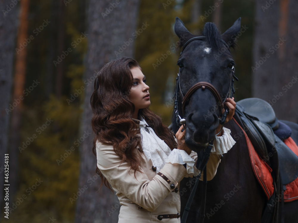 Obraz premium Portrait of a rider in a retro suit and her black horse.