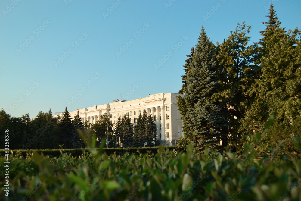 Trees and historic building on blue sky background