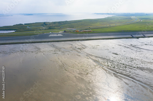 Drone photography of the mudflat coastline at low tide with water winding in the mud and sand bank near Lauwersoog, Friesland, The Netherlands photo