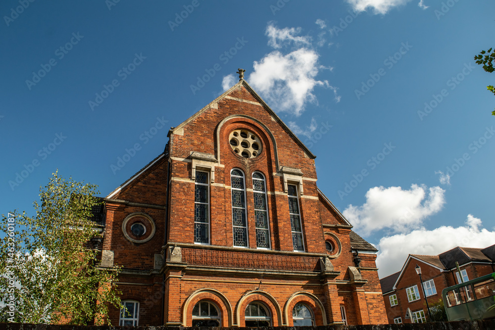 Top side of brick church with tall stained glass at Saffron Walden, England