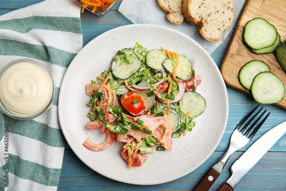 Plate of delicious vegetable salad dressed with mayonnaise served on light blue wooden table, flat lay Plate of delicious vegetable salad dressed with mayonnaise served on light blue wooden table, flat lay