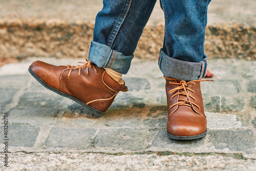 Close up image of brown leather vintage shoes wearing by a child