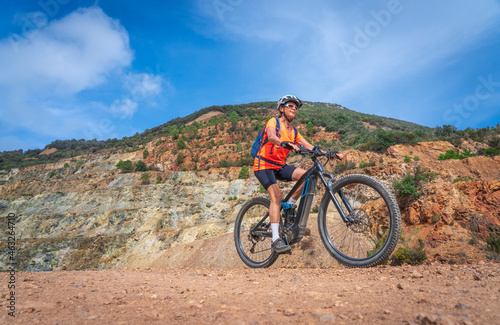 nice active woman riding her electric mountain bike in the abandoned Iron Ore mines of Calamite peninsula on the Island of Elba, Tuscan Archipelago, Tuscany,Italy 