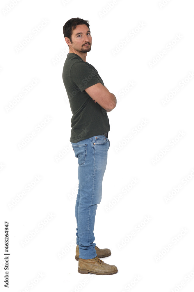 full portrait of a man in profile looking at camera and arms crossed on white background full portrait of a man in profile looking at camera and arms crossed on white background