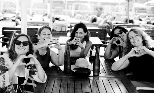Women best friends sitting in summer cafe on the beach