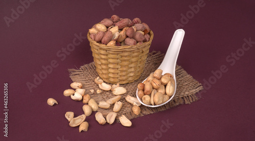 Groundnuts in wooden bowl isolated on plane background, salted roasted peeled nuts, top view
